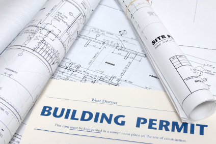 A real building permit and the blueprints it covers, laid out together